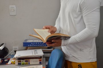 Imagem de um homem segurando um livro.