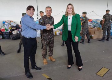 Imagem da juíza com o representante da FIEPB e donativos ao fundo